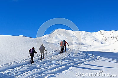 Group of people hiking on snowshoes and mountain snow panorama with blue sky in Stubai Alps Stock Photo