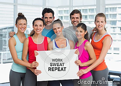 Group of people holding card with text work, sweat and repeat in front of window in gym Stock Photo