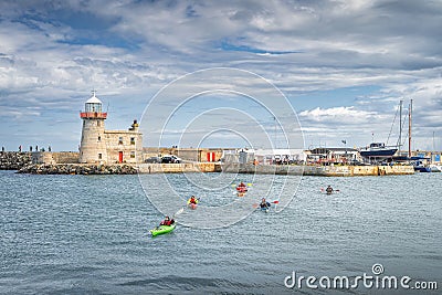 Group of people kayaking in Howth marina with Howth Lighthouse in background Editorial Stock Photo