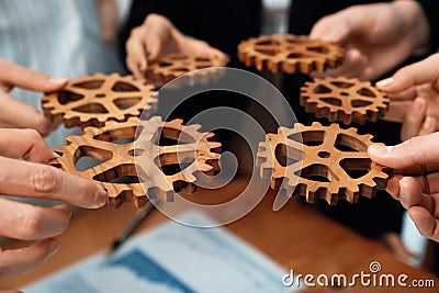 Group of people making chain of gears into collective form for harmony symbol. Stock Photo