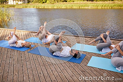 Group of people making yoga exercises outdoors Stock Photo