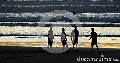 Group of People playing Football on Cabourg Beach at Sunset, Normandy Stock Photo
