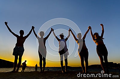 Group of People with Raised Arms backlit by sun Stock Photo