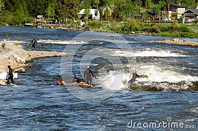 Group of people river surfing in the whitewater park. Bend, Oregon, USA Editorial Stock Photo