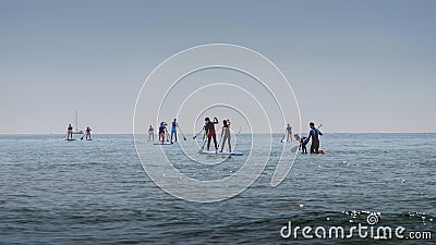 Group of people in sea train Stand Up Paddling. Outdoor sporting activity. Summer Landscape Editorial Stock Photo