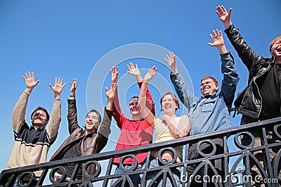Group of people stand with hands lifted in greet Stock Photo