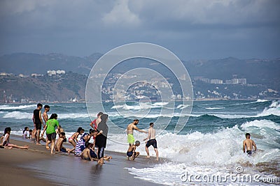 Group of people standing in the sea foam in Jeanne D`arc beach. Editorial Stock Photo