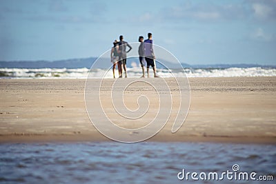 group of people standing talking on Guaibim beach in Valenca, Bahia Editorial Stock Photo