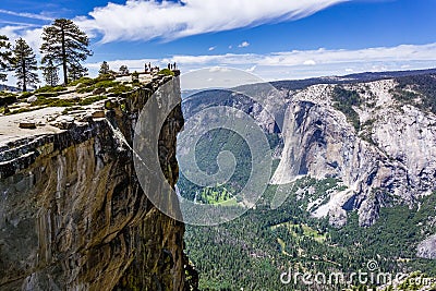 A group of people visiting Taft Point, a popular vista point; El Capitan, Yosemite Valley and Merced River visible on the right; Stock Photo