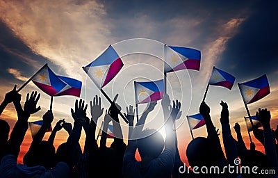 Group of People Waving Filipino Flags in Back Lit Stock Photo