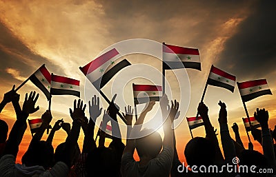 Group of People Waving Flag of Syria in Back Lit Stock Photo