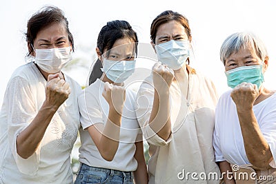 Group of people wearing medical mask to prevent infection from spreading of Covid-19,asian family raised a fists and prepare for Stock Photo