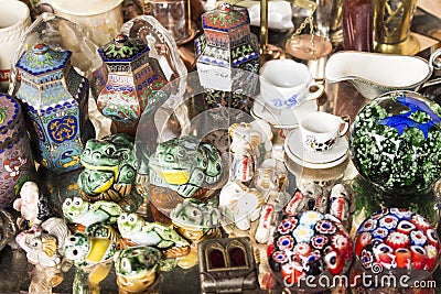 Group of porcelain decorative objects and some utensils. There are frogs, cups and jars. Stock Photo