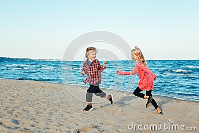 Group portrait of two funny white Caucasian children kids friends playing running on beach on sunset Stock Photo