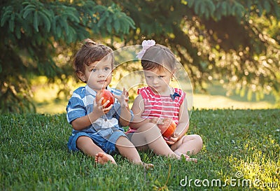 Funny children toddlers sitting together sharing apple food Stock Photo