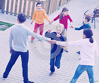 Group of positive children playing red rover Stock Photo