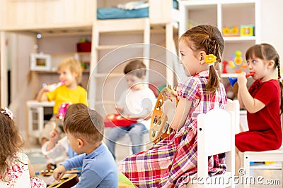 Group of preschooler children playing with musical toys at kindergarten Stock Photo