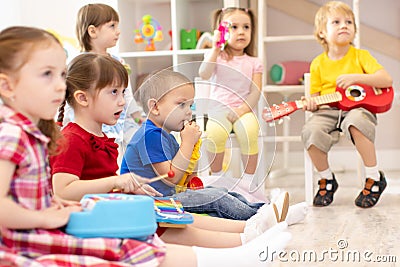 Group of preschooler children playing with musical toys at kindergarten Stock Photo