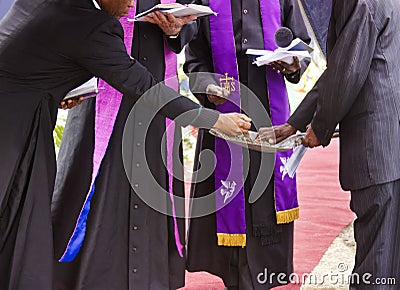 group of priests reading prayers at a funeral Editorial Stock Photo