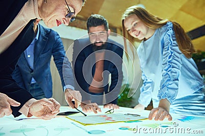 Group of professionals, colleagues engaged in strategic planning session with graphs and charts. Launching startup Stock Photo