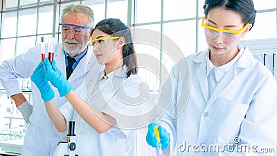 Group of Professor researcher scientist with white gown prepare testing chemical liquid with science equipments on desk. with face Stock Photo