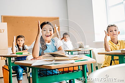 group of pupils raising hands to answer question Stock Photo