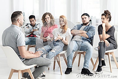 Group of rebellious teenagers talking to a psychotherapist about Stock Photo