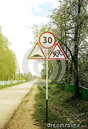 Group of road signs with speed limit, running around children, a dangerous section of a village road Stock Photo