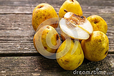 Group of rotting pears, focus on the half cutted fruit Stock Photo