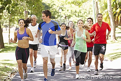 Group Of Runners Jogging Through Park Stock Photo