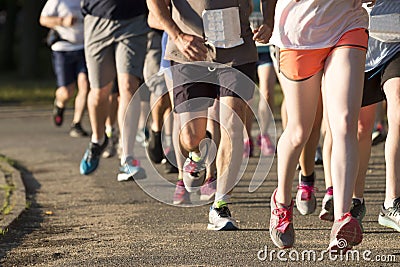 Group of runners racing a 5K on a dirt path Stock Photo