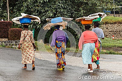 Group of Rwandan women in colorful traditionals clothes wearing washbowls on their heads, Kigali, Rwanda Editorial Stock Photo