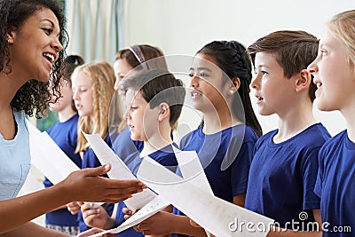 Group Of School Children With Teacher Singing In Choir Stock Photo