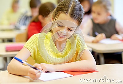 Group of school kids writing test in classroom Stock Photo