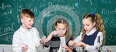 Group school pupils study chemical liquids. School laboratory. Girls and boy conduct experiment with liquids. Teamwork Stock Photo