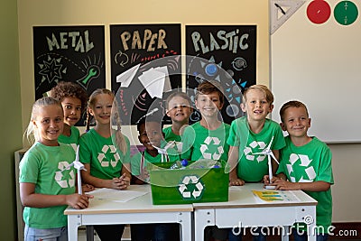 Group of schoolchildren wearing green t shirts with a white recycling logo on them Stock Photo