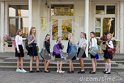 A group of schoolgirls with backpacks go to school Stock Photo