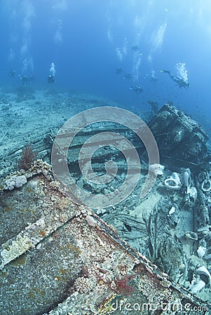 Group of scuba divers exploring a shipwreck. Stock Photo