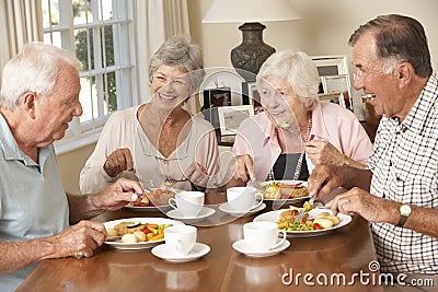 Group Of Senior Couples Enjoying Meal Together Stock Photo