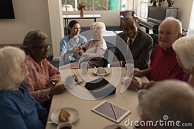 Group of senior friends having breakfast on dining table at nursing home Stock Photo