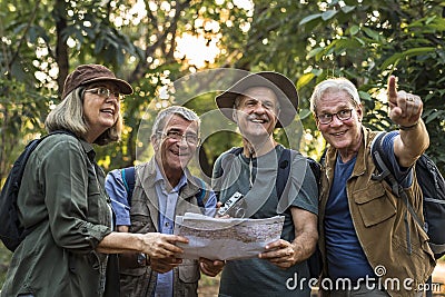 Group of senior trekkers checking a map for direction Stock Photo