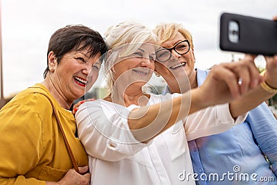 Senior women using mobile phone together Stock Photo
