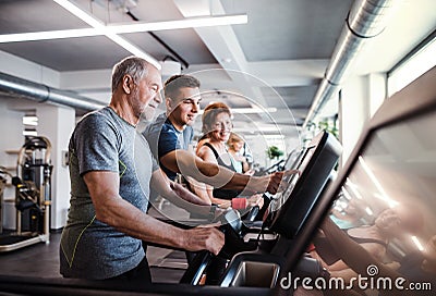 A group of seniors in gym with a young trainer doing cardio work out. Stock Photo