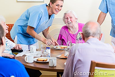 Group of seniors having food in nursing home Stock Photo