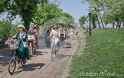 Group of seniors and young women in old fashion style cycling with vintage bicycle at festival Retro Cruise Editorial Stock Photo
