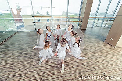 Group of seven little ballerinas sitting on the floor. They are good friend and amazing dance performers Stock Photo