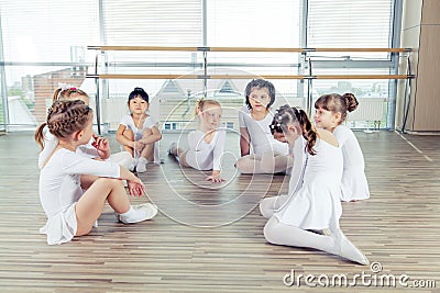 Group of seven little ballerinas sitting on the floor. They are good friend and amazing dance performers Stock Photo