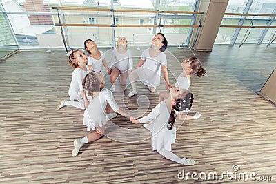 Group of seven little ballerinas sitting on the floor. They are good friend and amazing dance performers Stock Photo