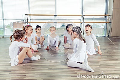 Group of seven little ballerinas sitting on the floor. They are good friend and amazing dance performers Stock Photo