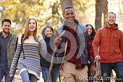 Group of six friends hiking together through a forest Stock Photo